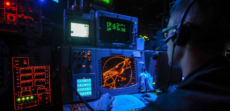 Operations Specialist 2nd Class Alex Moore monitors radars to identify aircraft in the Combat Information Center aboard the multipurpose amphibious assault ship USS Bataan.  U.S. Navy Photo