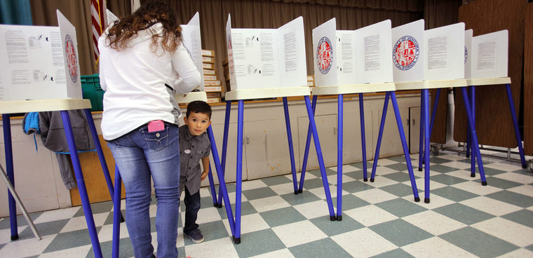 Boy looks under voting booth at Ventura Polling Station for California primary Ventura County, California. Joseph Sohm / Shutterstock.com