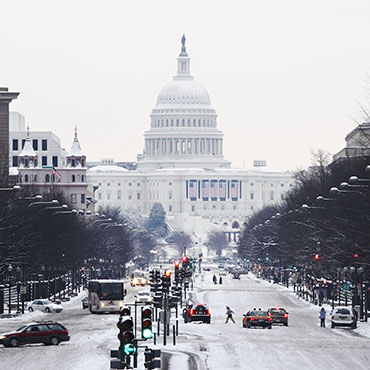 Shutterstock image (by fstockfoto): the United States Capitol covered in snow, as seen from Pennsylvania Avenue.