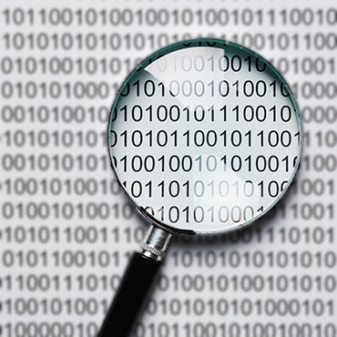 Shutterstock image (by Laborant): clear magnifying glass, blurred binary code.