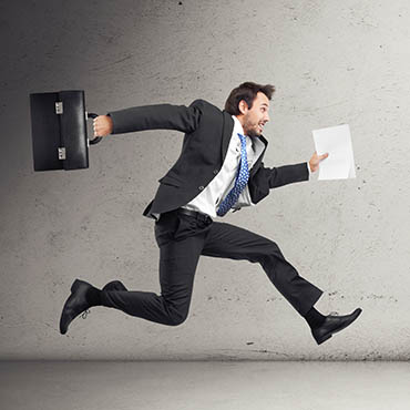 Shutterstock image (by Sfio Cracho): businessman running with papers and a briefcase.