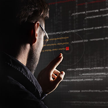Shutterstock image (by GlebStock): hacker with graphic user interface.