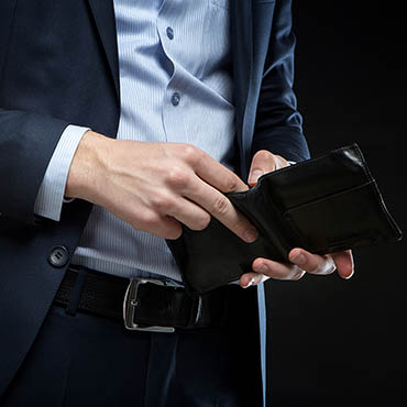 Shutterstock image (Roman Seliutin): Businessman checking his wallet.