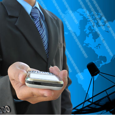 image of man holding mobile device with world map and satellite dish in background
