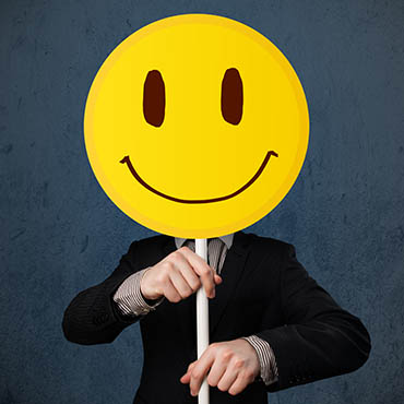 Shutterstock image (by ra2studio): businessman holding a smiley face emoticon.